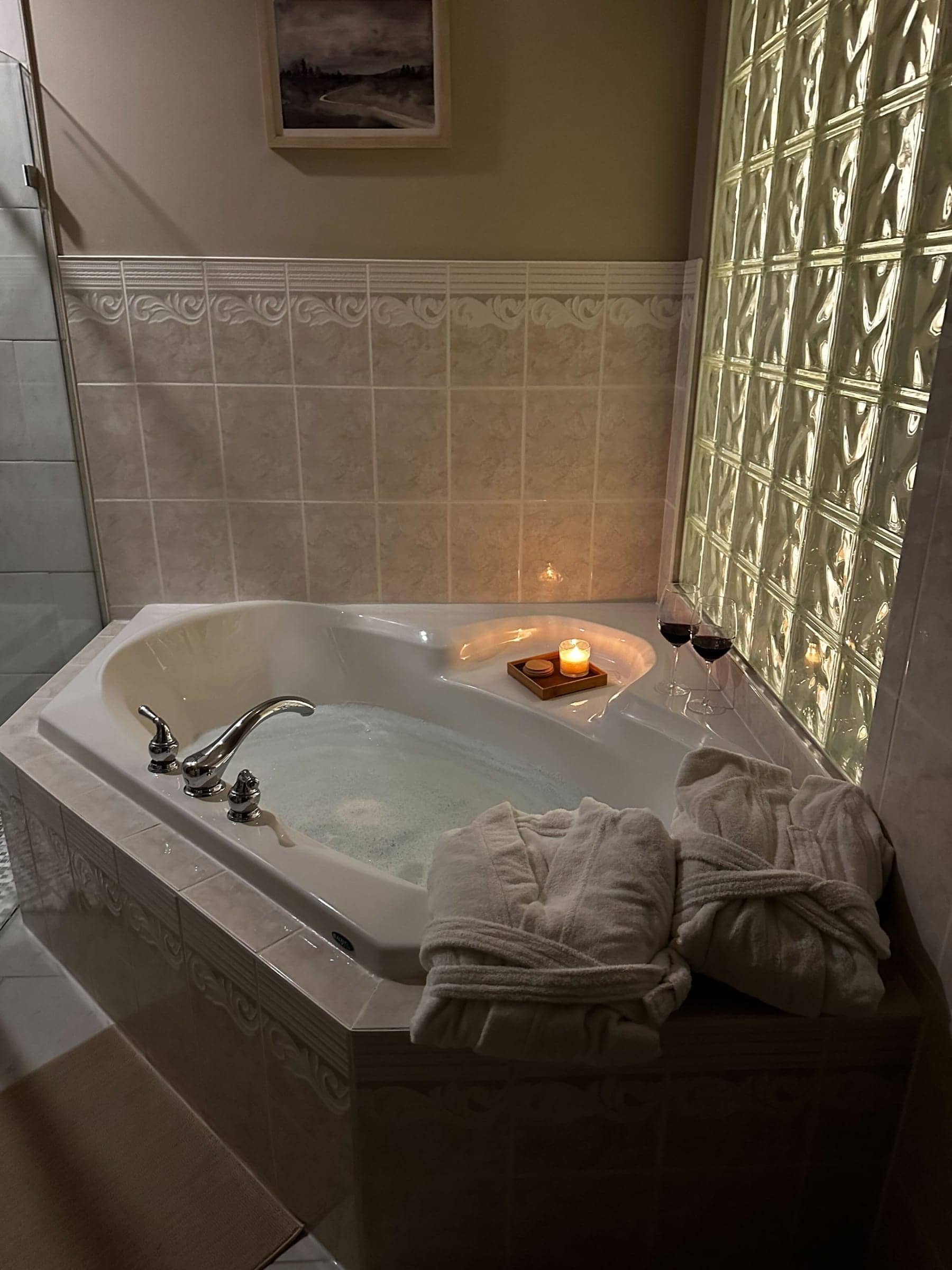 Candlelit soaker bath filled with water, with Epsom salts and towels