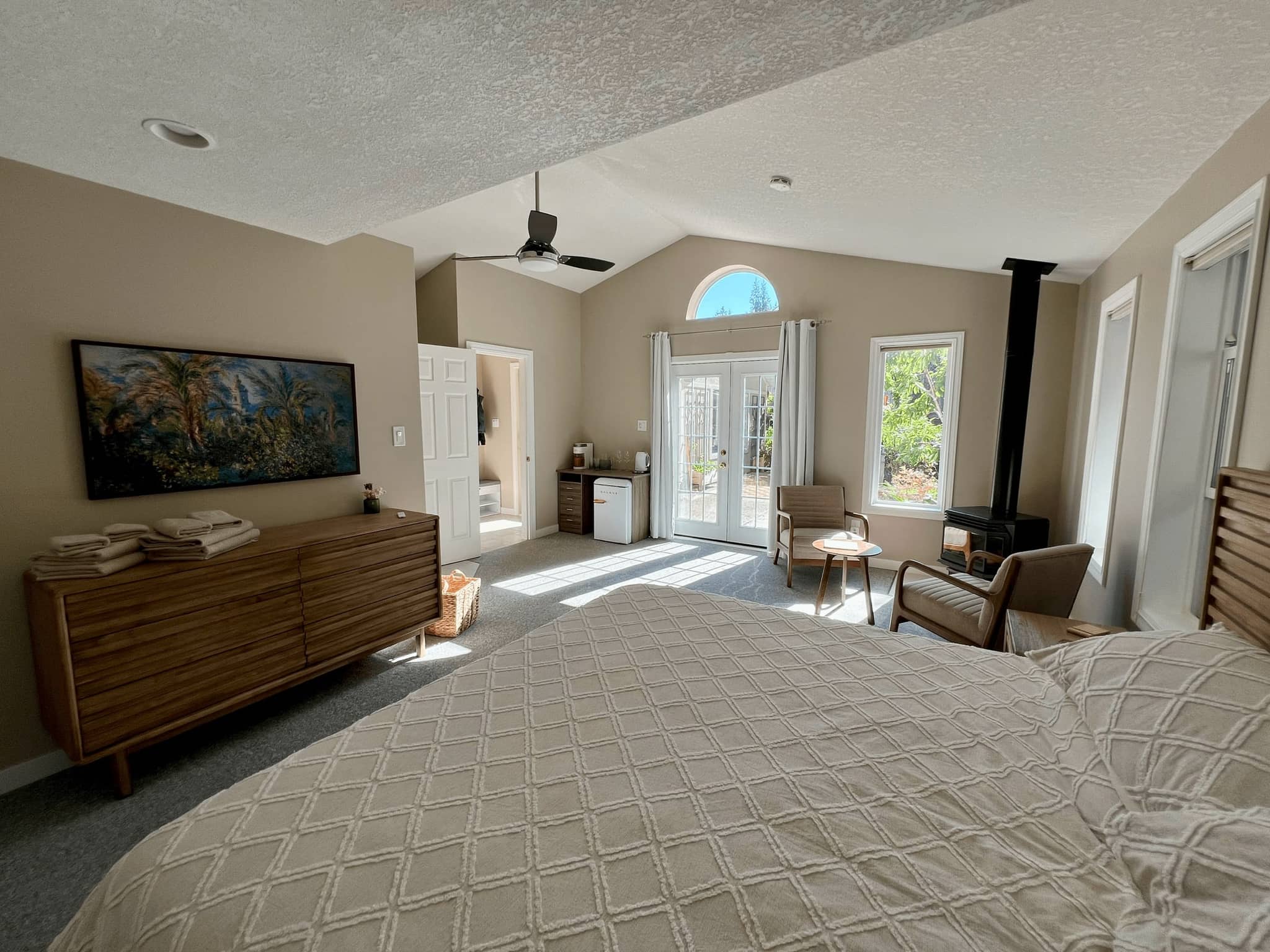 Spacious private suite with king bed, vaulted ceiling, gas stove fireplace and French doors to the garden
